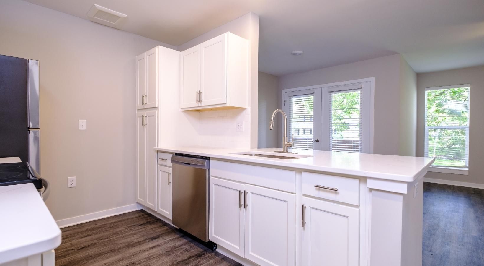 Wide open living areas flooded with natural light a kitchen with white cabinets