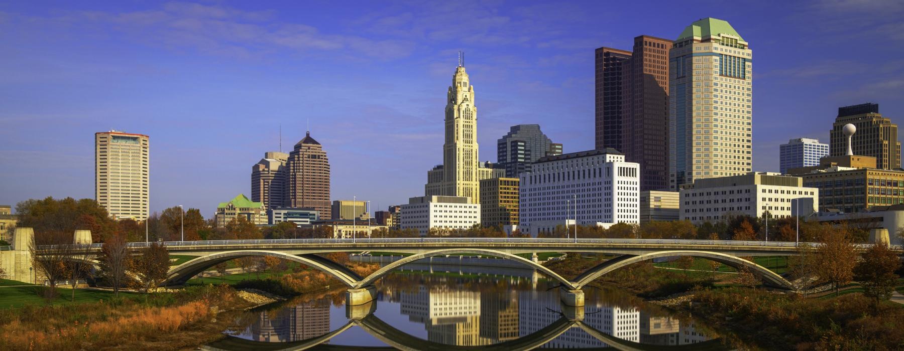 a city skyline with a bridge over a body of water