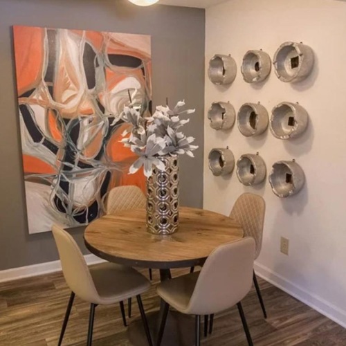 a table with chairs and a vase with flowers on it
