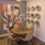 a table with chairs and a vase with flowers on it