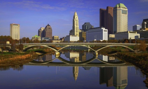a city skyline with a bridge over a body of water