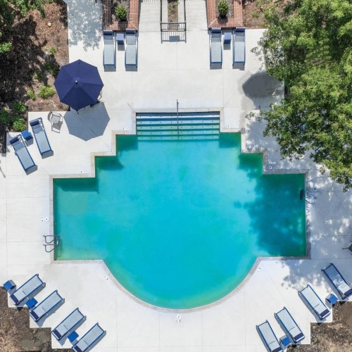 Relax and unwind poolside a pool in a courtyard