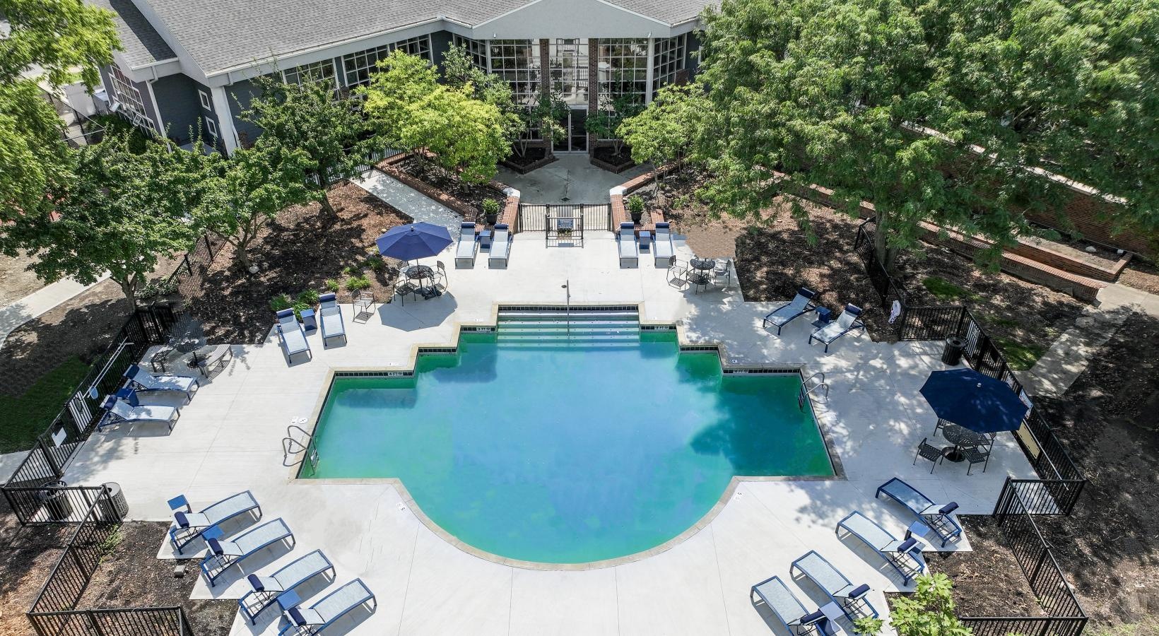 The essence of exceptional living a swimming pool with chairs and umbrellas in a backyard